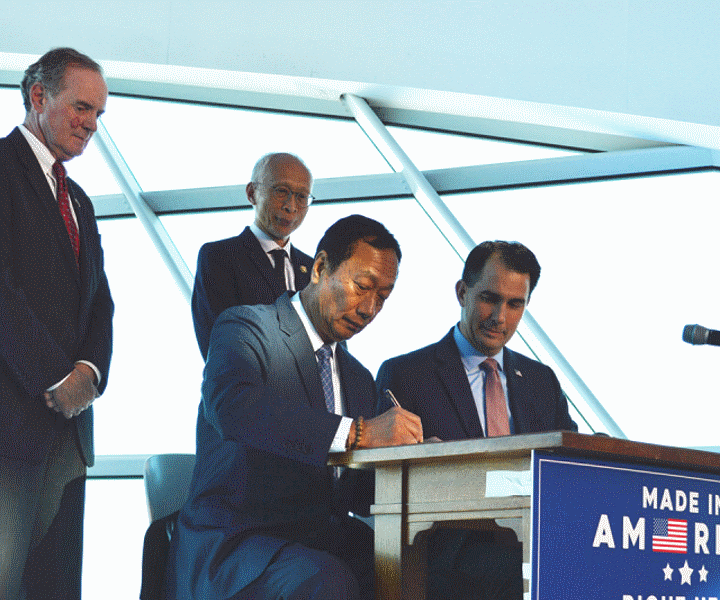 Foxconn chairman Terry Gou and Governor Scott Walker signing a memorandum of understanding. Second row: Mark R. Hogan, secretary and CEO of WEDC and Dr. Louis Woo. Photo from the State of Wisconsin.