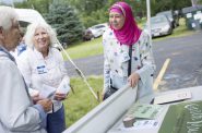 Huda Akaff, founder and director of Wisconsin Green Muslims, speaks with sister Caryl Hartjes, a member of the congregation of sisters of St. Agnes, who have installed about 800 solar panels already and halved their electric bill, and Karen Ingvoldstad, about solar energy at the Interfaith Dialogue held at the Fox Valley Islamic Society on Aug. 6, 2017 in Neenah, Wis. Photo by Michelle Kanaar.