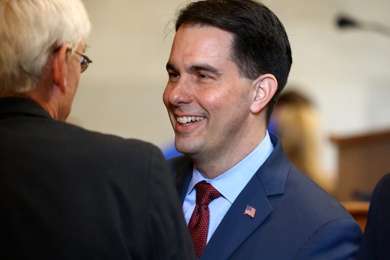 Gov. Scott Walker signed the 2015-17 budget that eliminated the state's False Claims Act, which had provided incentives to whistleblowers and extra money for the state in cases of Medicaid fraud. Here he greets State Superintendent of Public Instruction Tony Evers prior to delivering his budget address at the State Capitol in Madison, Wis., Feb. 8. Photo by Coburn Dukehart / Wisconsin Center for Investigative Journalism.