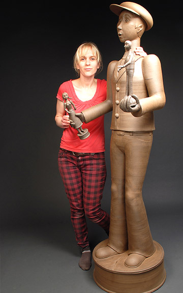 Gerit Grimm standing next to the peddler of The Peddler and Female Shopper, Stoneware, 2011. Photo from MOWA.