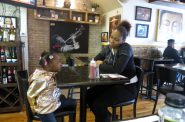 Davina Turner and her daughter, Madison, enjoy the decor at Mi Casa Su Cafe, much of which came from the homes of co-owners Jameel Trotter and Paul Whigham. Photo by Talis Shelbourne.