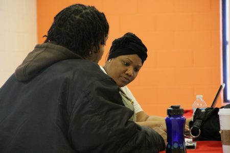 Shanyeill McCloud of Clean Slate Milwaukee checks a man’s criminal record, to see if he is eligible for expungement, during an event in 2016. Photo by Scottie Lee Meyers.