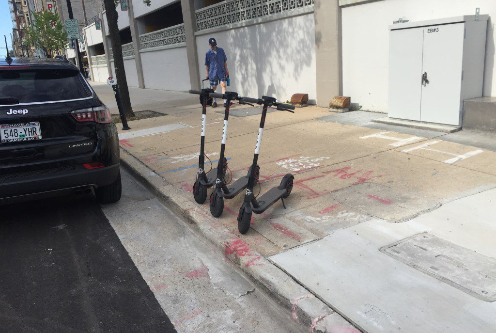 Three of Bird's scooters were parked on N. Milwaukee St. on the morning of July 9th, 2018. Photo by Dave Reid.