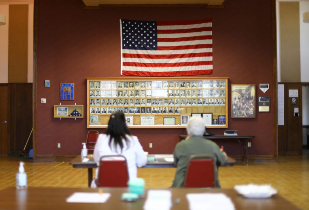 Julie Routhieaux, administrative specialist for the village of Little Chute, Wisconsin, left, and Patti Seeman, an election inspector, help out with voting at the village hall for a special election in the 1st Senate District on June 12, 2018. Democrat Caleb Frostman beat Republican Andre' Jacque for the state Senate seat. A judge had ordered Gov. Scott Walker to call a special election for the seat after the former office holder, Republican Frank Lasee, resigned in December to take a job with the state. Photo by Coburn Dukehart/Wisconsin Center for Investigative Journalism.