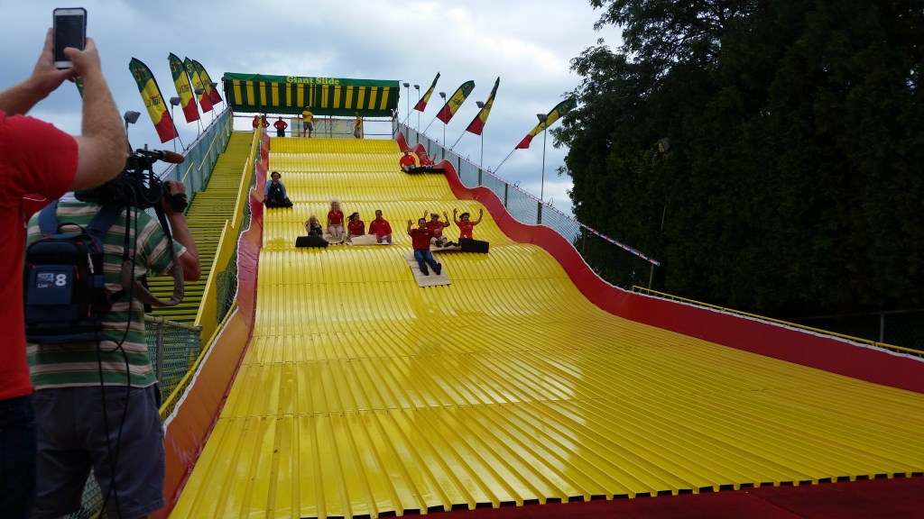 Gov. Scott Walker goes down the Giant Slide at the Wisconsin State Fair, as the fair opens its ten-day run in West Allis. Photo by Chuck Quirmbach/WPR.