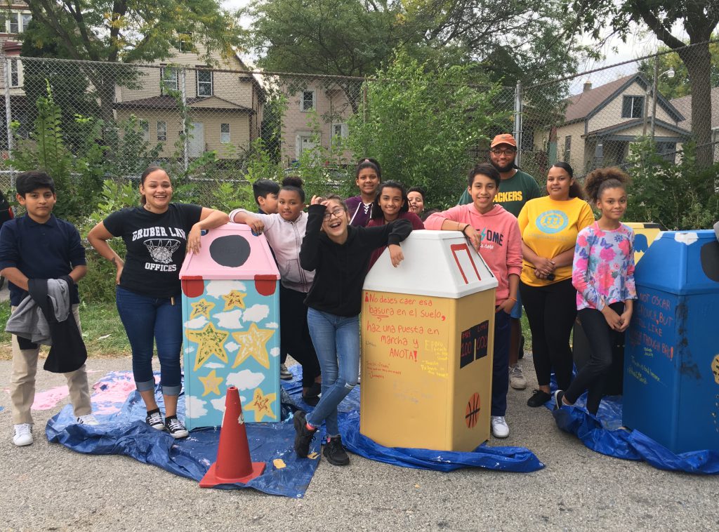 Myron Edwards, District 2 youth organizer for Safe & Sound, and young people from Journey House pose with their ‘beautiful garbage’ receptacles. Photo by Myron Edwards, courtesy of Safe & Sound/NNS.