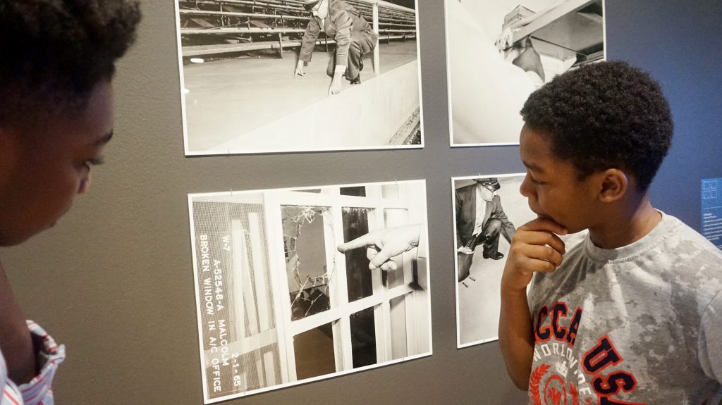 Lorenz Ambose, 12, (left) and Carmello Mitchell, 10, study a photo in the exhibit. Photo courtesy of NNS.