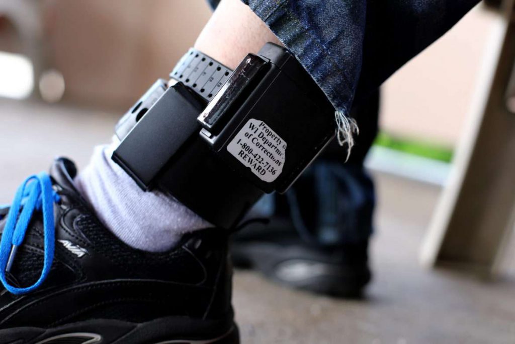 A registered sex offender shows his GPS ankle bracelet. Many such offenders on electronic monitoring become homeless because of restrictive housing laws that prohibit them from living near schools, parks and day-care centers. Photo by Coburn Dukehart/Wisconsin Center for Investigative Journalism.