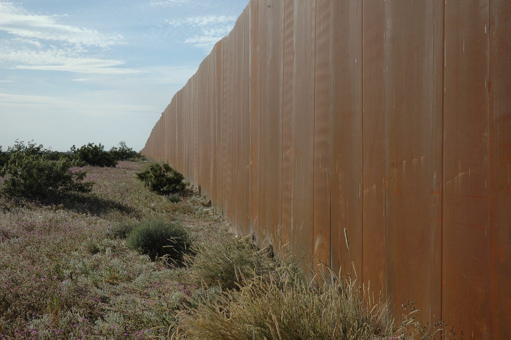 A wall seperating the US and Mexico. Photo by Wonderlane. (CC BY 2.0)