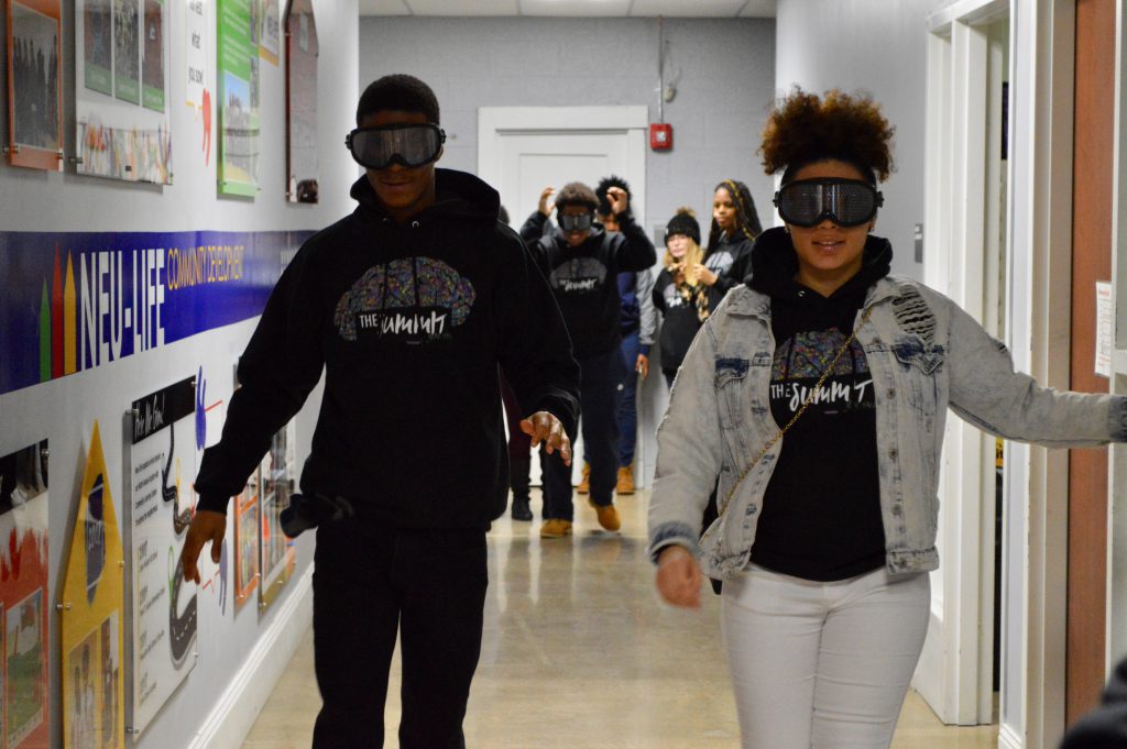 Two students attempt to walk down the hallway wearing “impairment goggles” that blurred their vision in a way that a person impaired by drugs would experience. Photo by Analise Pruni/NNS.