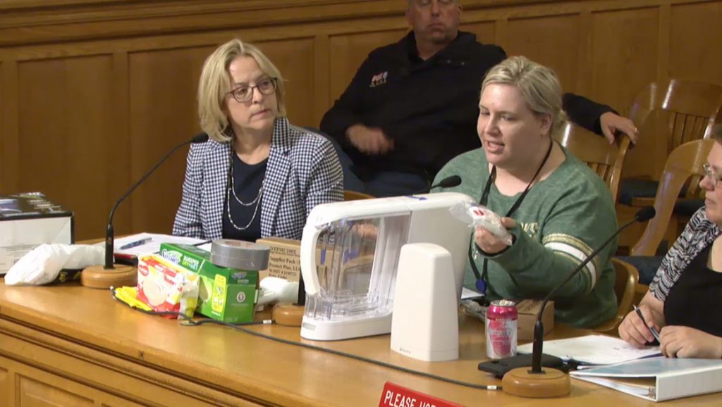MHD employee Jean Schultz highlights the different lead-safe water filters and products to a Common Council committee. Image from City Channel 25.