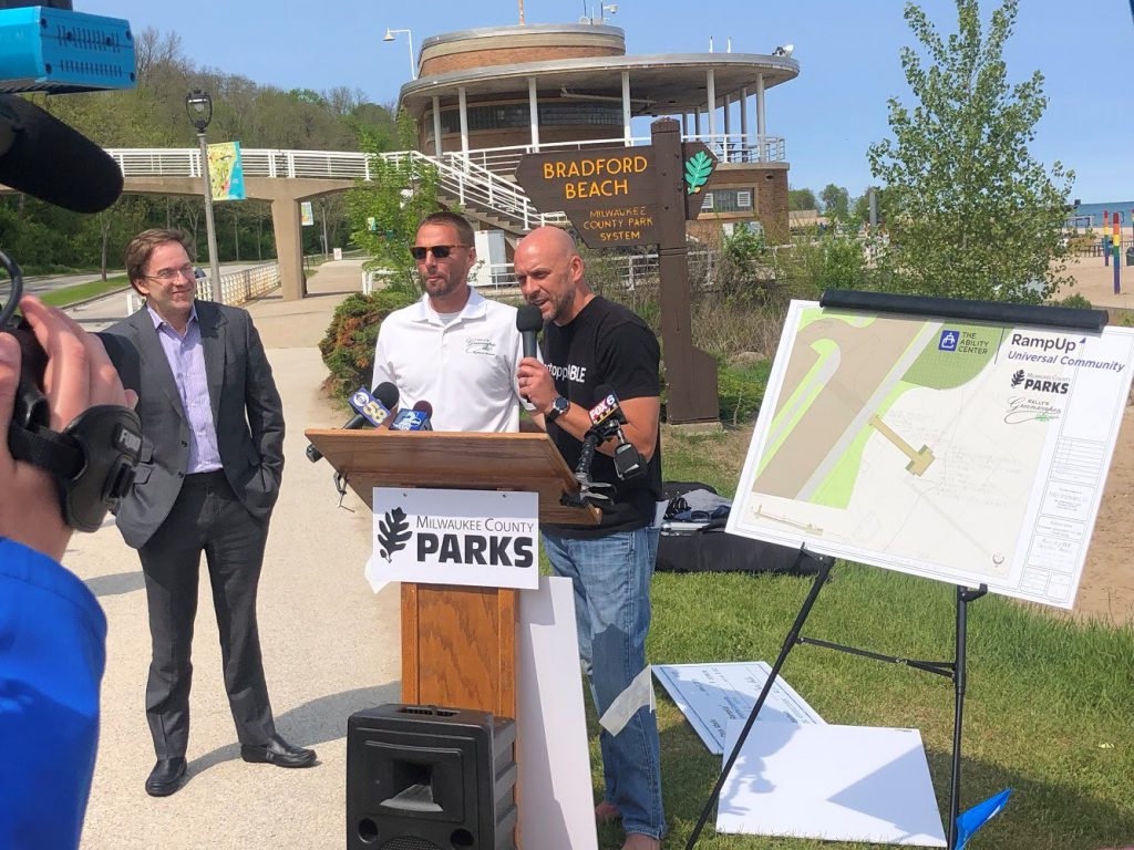 Damian Buchman, right, (Milwaukee County Executive Chris Abele, far left) announcing plan for permanent ramp at Bradford Beach. Photo from The Ability Center.