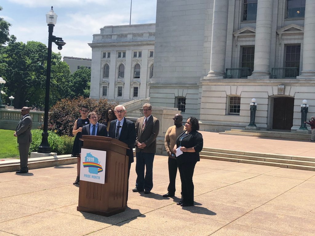The governor, state lawmakers and members of the LGBTQ community gathered at the state Capitol on Monday to celebrate Pride Month in Wisconsin and push for more state laws to protect and support the lesbian, gay, bisexual, transgender and queer community. Photo by Laurel White/WPR.
