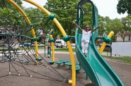 Denaja Shackelford, 5, lets loose on the slide at the Clarke Square playground, which was renovated by the county in 2013. Photo by Andrea Waxman/NNS.