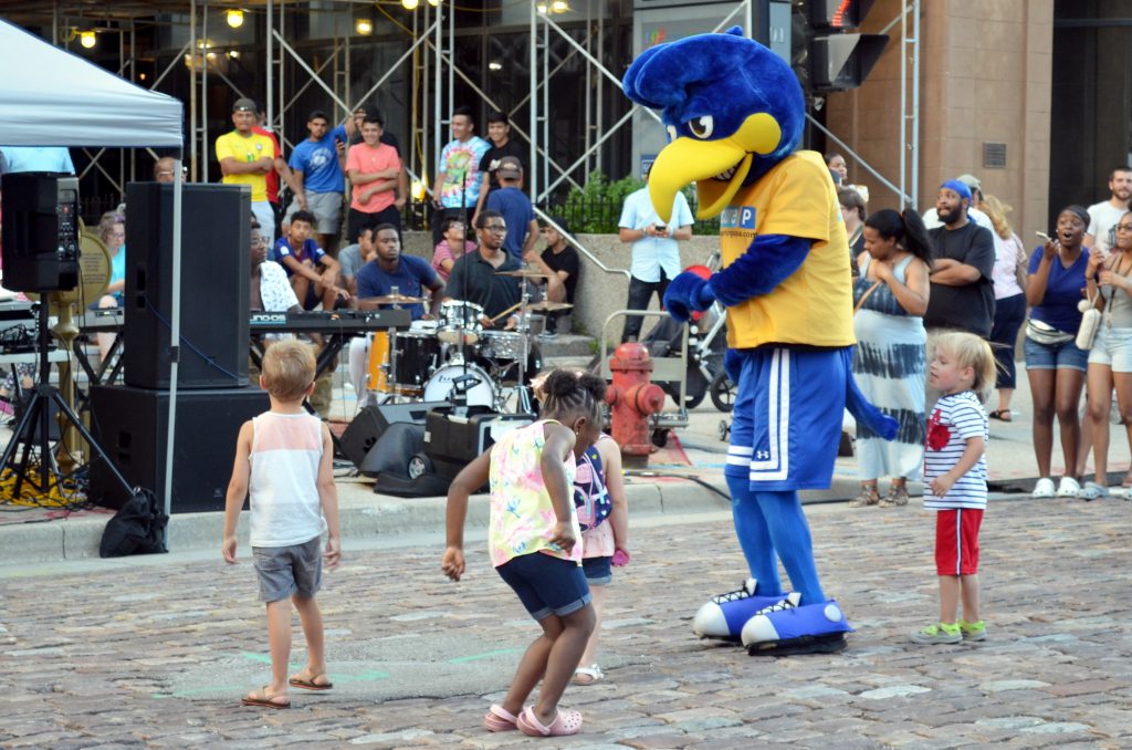 Children dance with the Secure Parking mascot at the Night Market. Photo by Jack Fennimore.