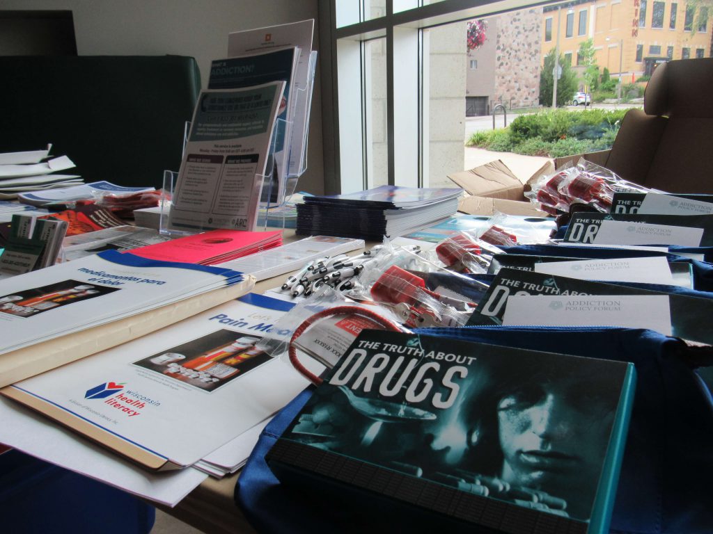A table filled with information available at the Bay View library for the recovery event. Photo by Isiah Holmes/Wisconsin Examiner.