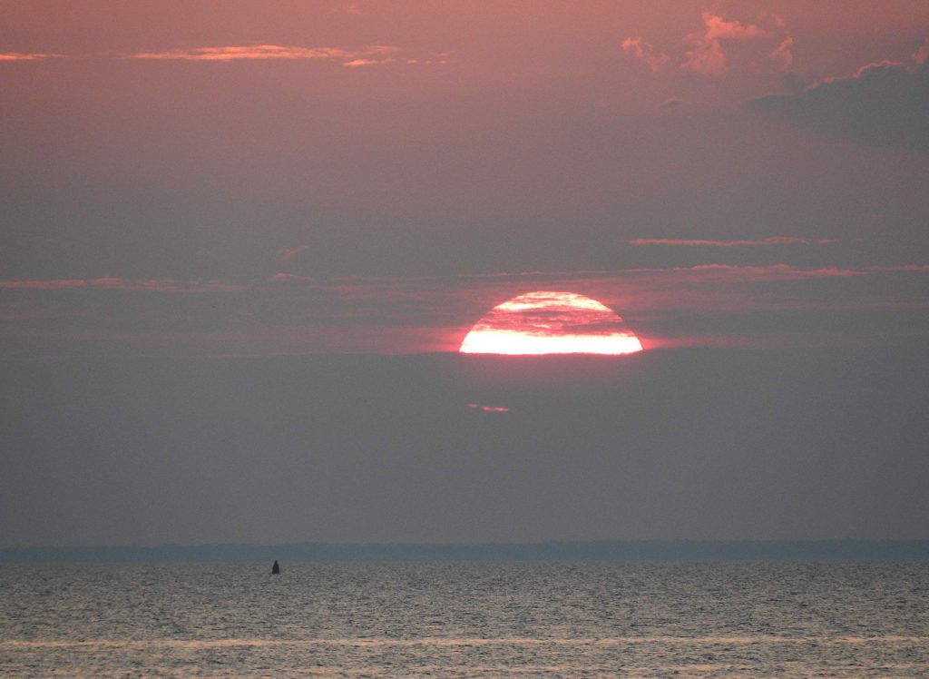 A summertime sun sets over the waters of Green Bay, as seen from Sunset Beach Park in Fish Creek in Door County. Photo by Brian Plunkett (CC BY 2.0) https://creativecommons.org/licenses/by/2.0/
