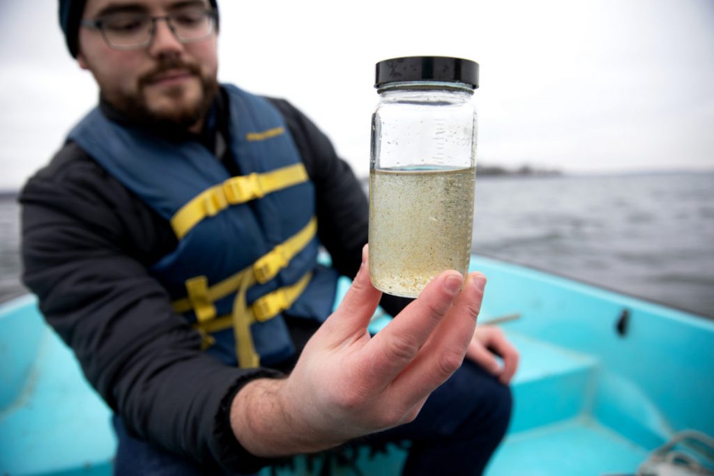 Jake Walsh, a postdoctoral researcher at the University of Wisconsin-Madison Center for Limnology, takes a water sample from Lake Mendota in Madison, Wis., on Nov. 16, 2018. Walsh was examining the zooplankton in the sample, including the invasive spiny waterflea. The species was unintentionally introduced into the Great Lakes through the discharge of contaminated ballast water from an ocean-going vessel. It was first discovered in Lake Ontario in 1982 and spread to Lake Superior by 1987. The waterflea was spread through Midwestern lakes by recreational boaters. Photo by Coburn Dukehart/Wisconsin Watch.
