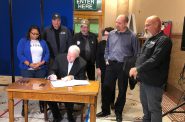 Mayor Tom Barrett signs veterans tiny homes proposal as Alderwoman Chantia Lewis and representatives of Veterans Outreach of Wisconsin look on. Photo by Jeramey Jannene.