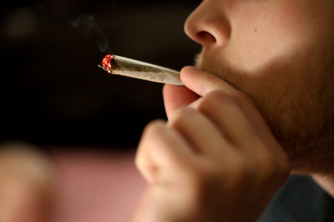 Across Wisconsin, there were more than 17,000 arrests for marijuana possession and more than 1,800 arrests for marijuana sales in 2018. Arrest and conviction records can make it harder to get jobs, professional licenses, housing, financial aid for higher education and government assistance. Here, a 23-year-old Madison, Wis., resident smokes a joint in a downtown apartment on March 31. Photo by Emily Hamer/Wisconsin Watch.