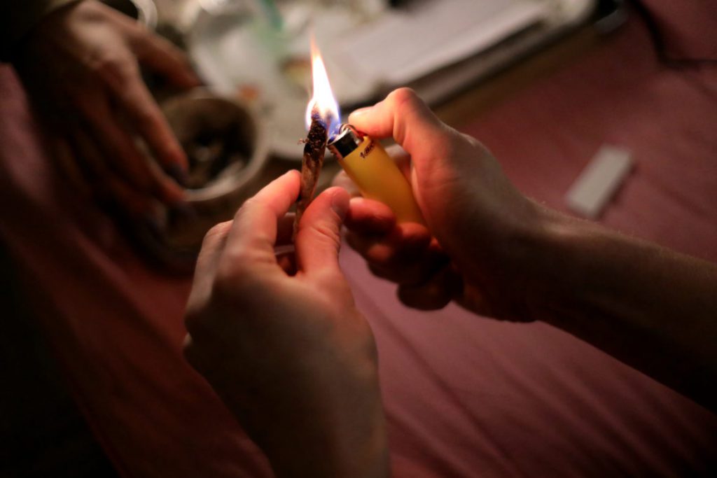 Wisconsin Gov. Tony Evers favors decriminalizing the possession, sale or manufacture of 25 grams or less of marijuana. The move comes as a growing swath of Wisconsin’s population favors legalizing or decriminalizing marijuana for at least some uses. Here, a 23-year-old Madison, Wis., resident lights a joint in a downtown apartment on March 31. Photo by Emily Hamer/Wisconsin Watch.