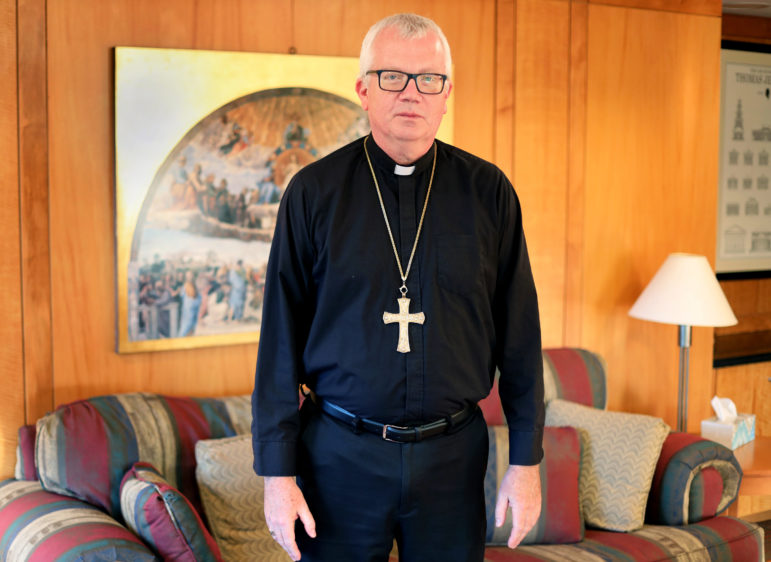 Bishop Donald Hying stands in his office at the Catholic Diocese of Madison in Madison, Wis., on Oct. 23, 2019. Soon after being installed as bishop in June, Hying spoke with Patricia Gallagher Marchant about the abuse she endured as a child in the diocese in 1965. Says Hying: “My door and heart are always open for speaking with victims as they may feel the need to come forward and speak.” Photo by Bram Sable-Smith / Wisconsin Public Radio.