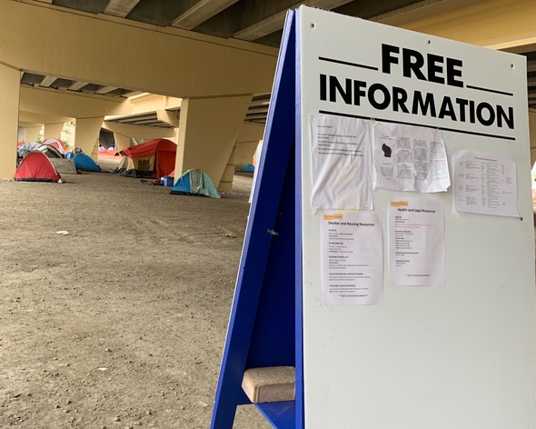 An easel sits under the Marquette Interchange where Milwaukee County and other non-profits post information about services for homeless residents on October 24, 2019 by Alana Watson, WPR.