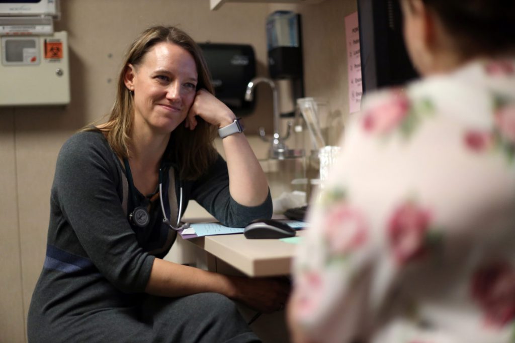 Dr. Angela Gatzke-Plamann is seen at the Necedah Family Medical Center in Necedah, Wis., on November 7, 2019, doing a check-in with Catina Stoflet, 35, who has been on medication-assisted treatment for seven months. “There isn’t another me just down the road. I’m the only one here,” says Dr. Gatzke-Plamann. “So if I can fulfill that need, then I should do that. And I don’t think that’s something that urban or suburban physicians have to deal with.” Photo by Coburn Dukehart/Wisconsin Watch.