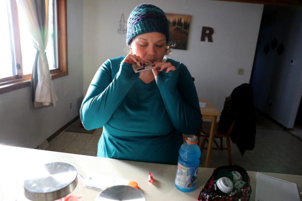 Catina Stoflet prepares to take one of two daily doses of Suboxone at her home in Wisconsin Rapids, Wis., on Dec. 3. Stoflet takes the Suboxone film twice a day by placing it under her tongue, while simultaneously sucking on a Jolly Rancher candy to mask the taste. Photo by Coburn Dukehart/Wisconsin Watch.