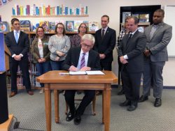 Gov. Tony Evers, center, vetoes the GOP-backed income tax cut Wednesday, Feb. 26, 2020, at Lincoln Elementary School in Wauwatosa, Wis. Photo by Corrinne Hess/WPR.