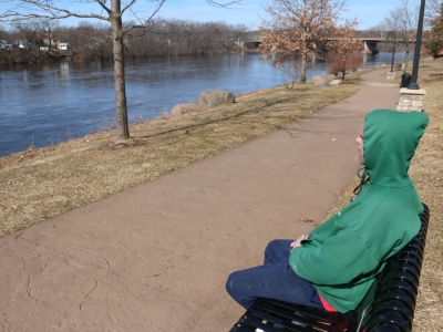 Jeff Honkanen, of Eau Claire, rests on a park bench in Phoenix Park near the city’s downtown. He said government imposed closures of libraries, restaurants and bars have been annoying, but he’s hopeful the efforts will keep the COVID-19 death tool in Wisconsin to a minimum. Photo by Rich Kremer/WPR.