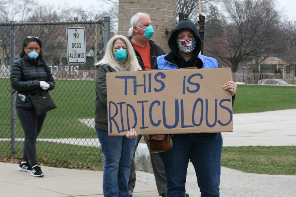 A voter waiting in line at Washington High School holds a sign that says "this is ridiculous." Photo by Jeramey Jannene.