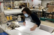 Stormy Kromer employee Penny Linnemanstons sews gowns that are being produced for health care workers and first responders during the coronavirus pandemic. Photo courtesy of Stormy Kromer/WPR.