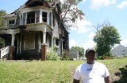 Corey Kirkwood stands in front of the burned home on N. 40th St. Photo by Jeramey Jannene.