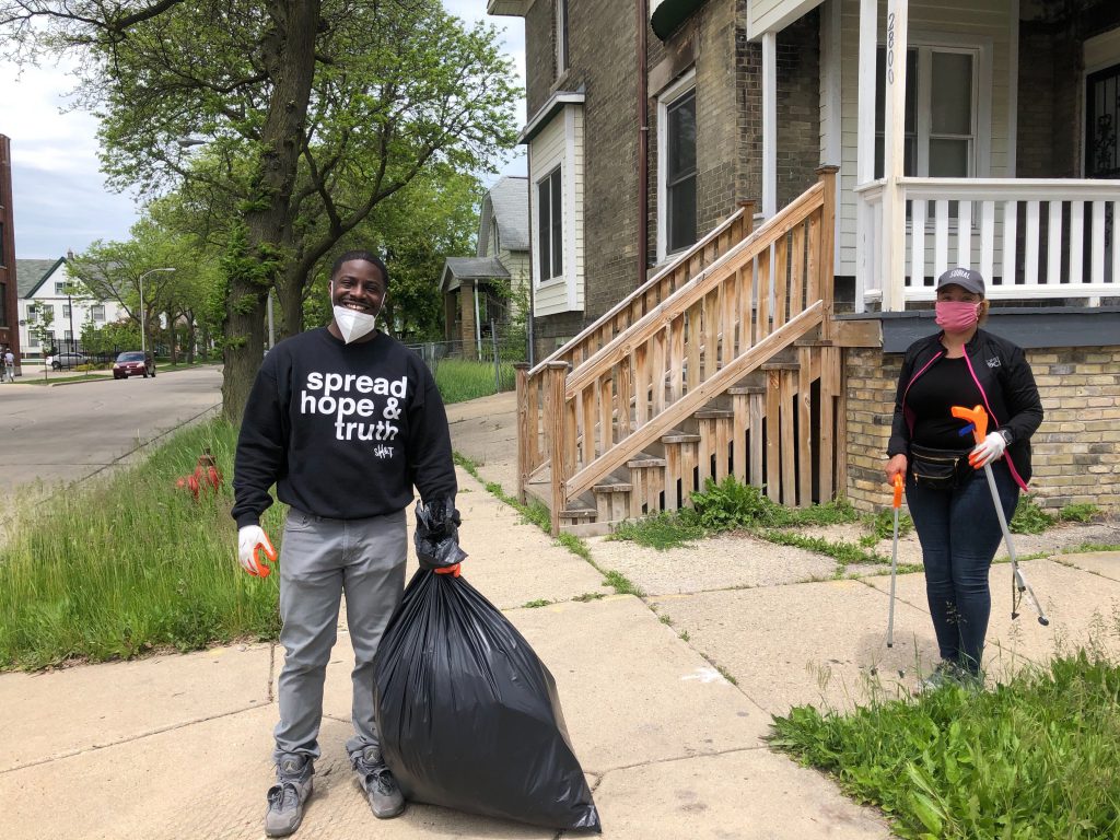 Milwaukee County Executive David Crowley carries a bag of garbage down the street during the June 1st cleanup. Photo by Jeramey Jannene.