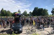 WebsterX (under umbrella atop the van) leads the crowd at a Black is Beautiful ride in a chant. Photo by Jeramey Jannene.