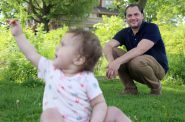 University of Wisconsin-Madison assistant professor Chris Cascio plays with his 14-month-old daughter Juniper in James Madison Park, near the apartment where he lives in Madison, Wis., on May 26, 2020. Cascio was surprised to learn he was on a list of more than 232,000 voters set to be deactivated from the Wisconsin voter rolls after he failed to update his unit number when moving apartments within the same building. While many voters like Cascio have updated their addresses, as of late May, the registrations of about 129,000 voters remained in question. Photo by Coburn Dukehart/Wisconsin Watch.