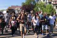 Frank Nitty (red hat) marches between Andre Tripplet (left) and Khalil Coleman (right). Photo by Jeramey Jannene.