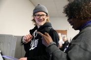 Asher Bernick-Roehr, a freshman at University of Wisconsin-Madison from St. Paul, Minn., casts his ballot during early voting on March 13, 2020, at the City Clerk’s office in Madison, Wis. He is assisted by absentee ballot clerk Teresa Holmes. College students in Wisconsin have additional requirements for voting that other voters do not face. Photo by Coburn Dukehart / Wisconsin Watch.