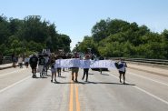 Black Lives Matter sign held by marchers crossing Locust Street bridge. Photo by Jeramey Jannene.
