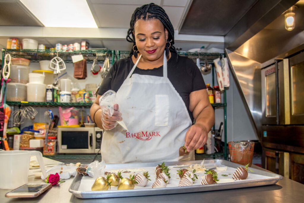 Adija Greer-Smith prepares chocolate-covered strawberries in the kitchen of her Milwaukee bakery, Confectionately Yours, on July 2, 2020. Photo courtesy of NNS.