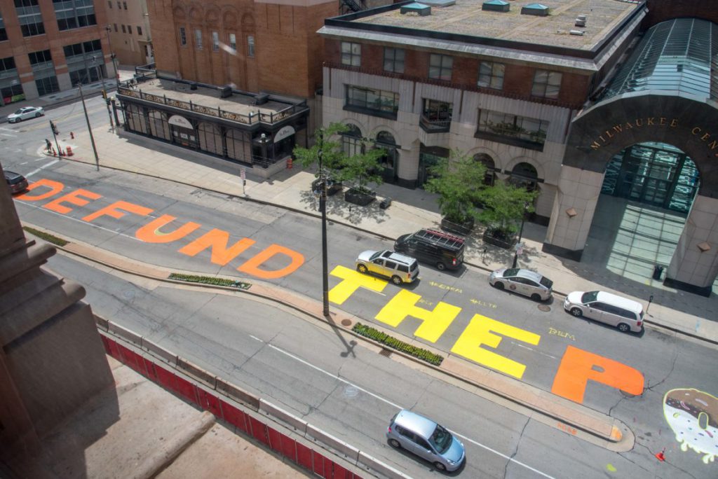 “Defund the police” is seen painted across a block of North Water Street in Milwaukee on July 2, 2020. The Milwaukee Department of Public Works removed the paint a week later, saying it presented “serious traffic safety concerns” because it covered traffic markings and was slick when wet. “The message painted on Water Street has been heard loud and clear by policy makers in city government, and the Department of Public Works has no intention to diminish the voices calling for change,” Commissioner of Public Works Jeff Polenske said in a July 9 statement. “Our concern for unauthorized street art including the current mural on Water Street is solely about safety.” Will Cioci/Wisconsin Watch.