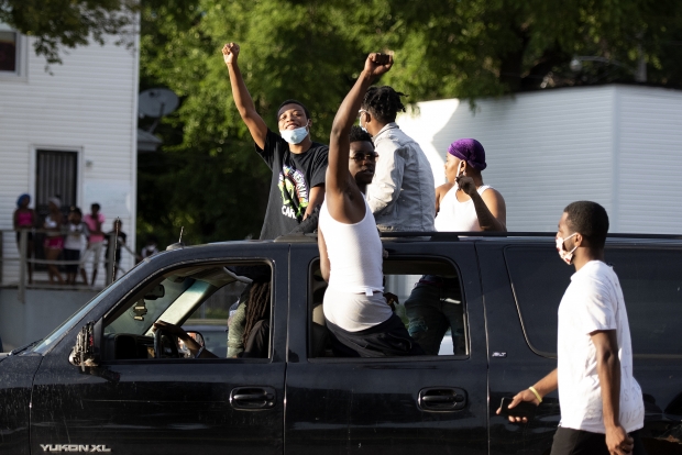 People raise their fists while riding in cars making the way for marching protesters Friday, Jul 31, 2020, near Washington Park in Milwaukee. Angela Major/WPR