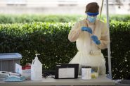 A COVID-19 test technician handles a test Wednesday, Aug. 19, 2020, at a pedestrian-friendly testing location at UW-Madison. Angela Major/WPR