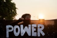 A protester holds a banner at the front of the crowd of marchers Monday, Aug. 24, 2020, in Kenosha. Angela Major/WPR