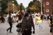 A protester who goes by Spaidez raises his fist as the protesters block off an intersection during their march Wednesday, Aug. 26, 2020, in Kenosha. Angela Major/WPR