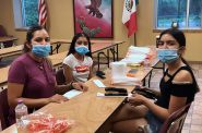 Volunteer Susy George and her daughters work on assembling masks. Photo provided by Laura Vasquez, WHSF/NNS.