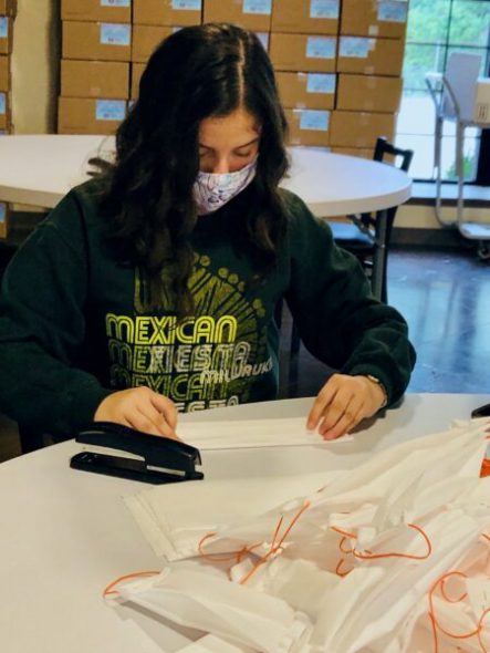 Volunteer Kalia Hernandez prepares a mask. Photo provided by Laura Vasquez, WHSF/NNS.