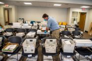 Election official Jim Fortner places a crate of sorted absentee ballots with others from the same ward at the Madison, Wis., City-County Building on Aug. 5, 2020. Madison elections workers alphabetized each returned absentee ballot by hand in preparation for Wisconsin’s partisan primary on Tuesday. Delays and failure to deliver absentee ballots in Wisconsin and other key swing states have sparked concerns about how well the November presidential election will be managed during the pandemic. Will Cioci/Wisconsin Watch