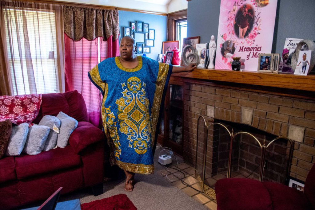 Wyconda Clayton is seen with pictures of family members inside her home in Milwaukee on July 17, 2020. She fell behind on rent while caring for her elderly mother, prompting her landlords to file for eviction. She received last-minute rental assistance through the state, but the landlords refused to accept it. She hopes to eventually remove the eviction from her public record under an agreement to move within 60 days. Photo by Will Cioci/Wisconsin Watch.